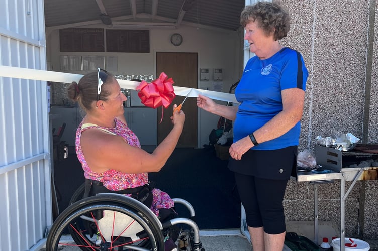 Paralympian Rachel Morris cuts the ribbon to open Badshot Lea Tennis Club’s floodlights and new accessible facilities chair, watched by club chair Gillian Hyman