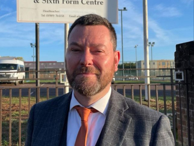 A photo of headteacher of John Kyrle High School (JKHS) Julian Morgan, standing outside of the school.